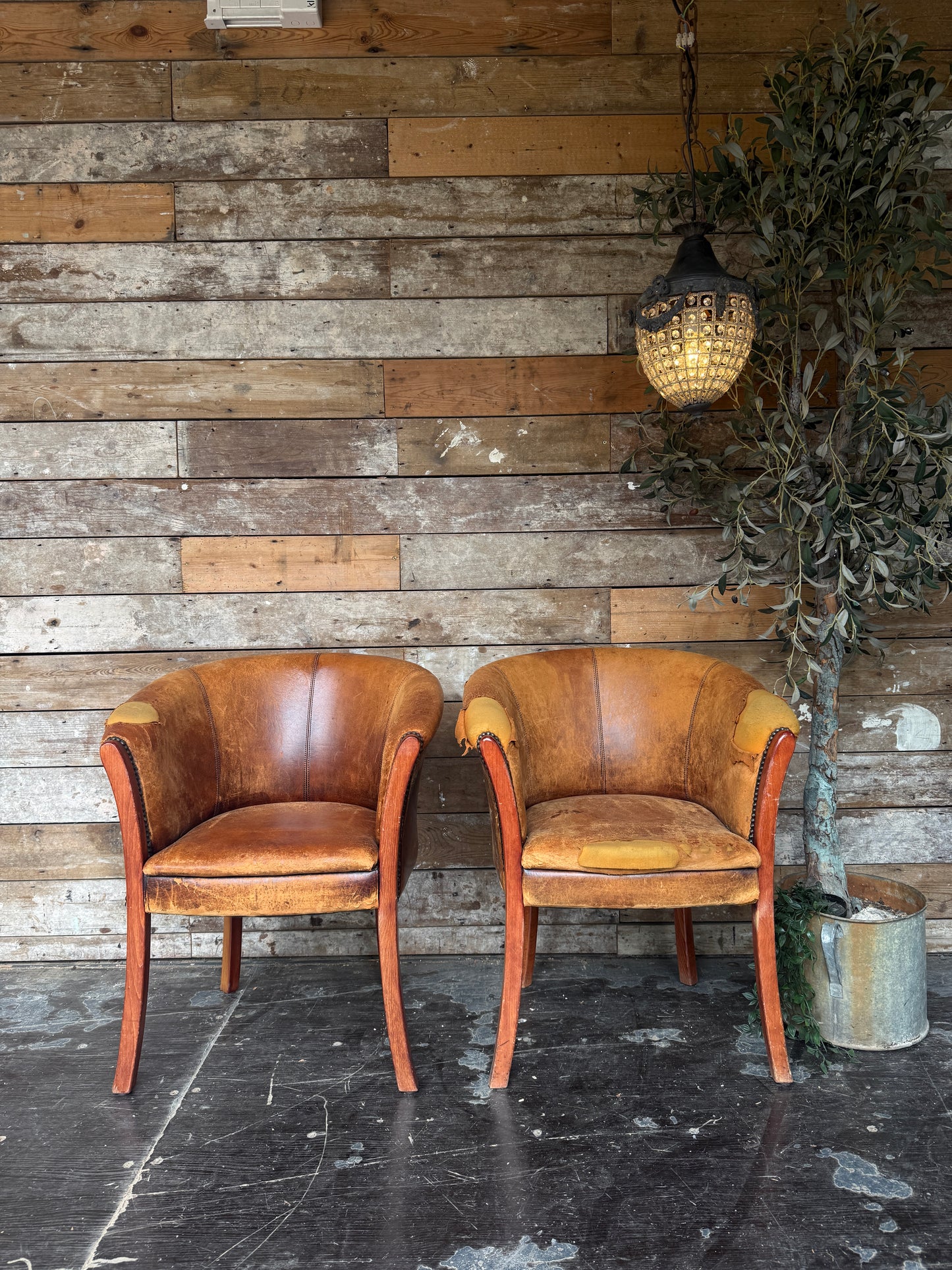 Pair of worn Dutch leather tub chairs